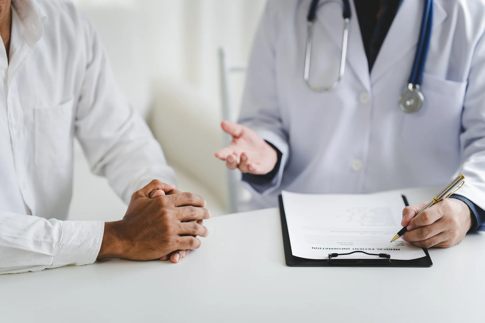 Patient assis face à un médecin discutant d’un dossier médical