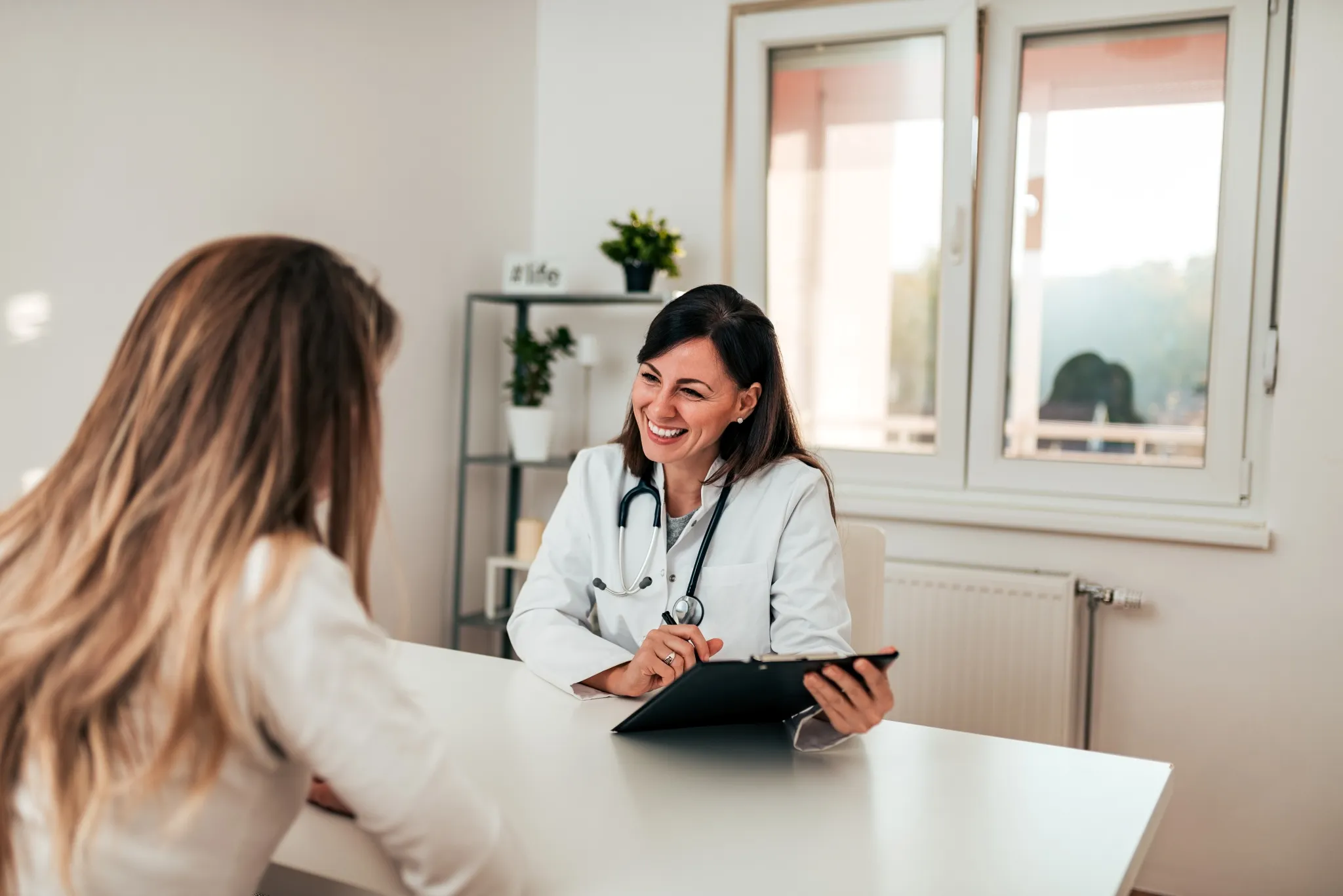 Médecin de famille souriante discutant d'un plan de santé avec sa patiente