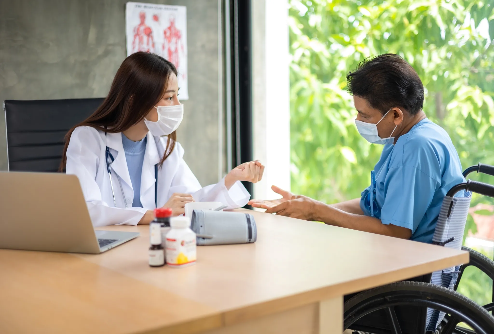 Consultation médicale entre une docteure et un patient en fauteuil roulant